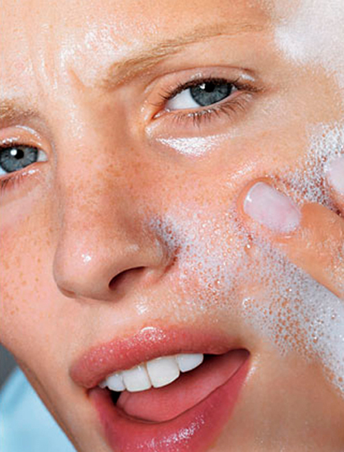 Imagen mujer lavándose la cara